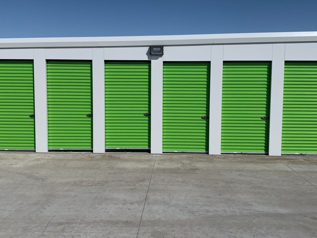 A row of green storage units with white walls