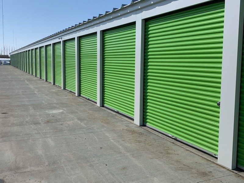 A row of green garage doors on a building