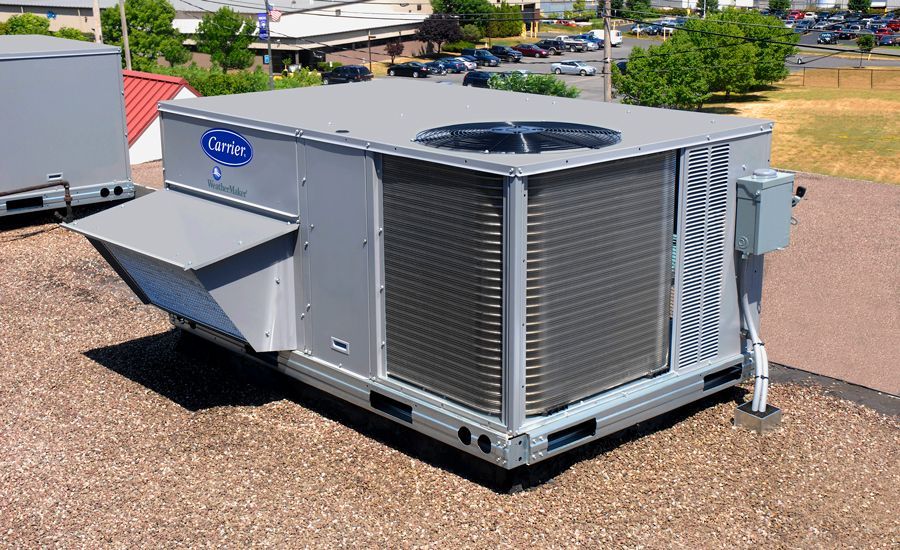 A carrier air conditioner is sitting on top of a gravel roof.
