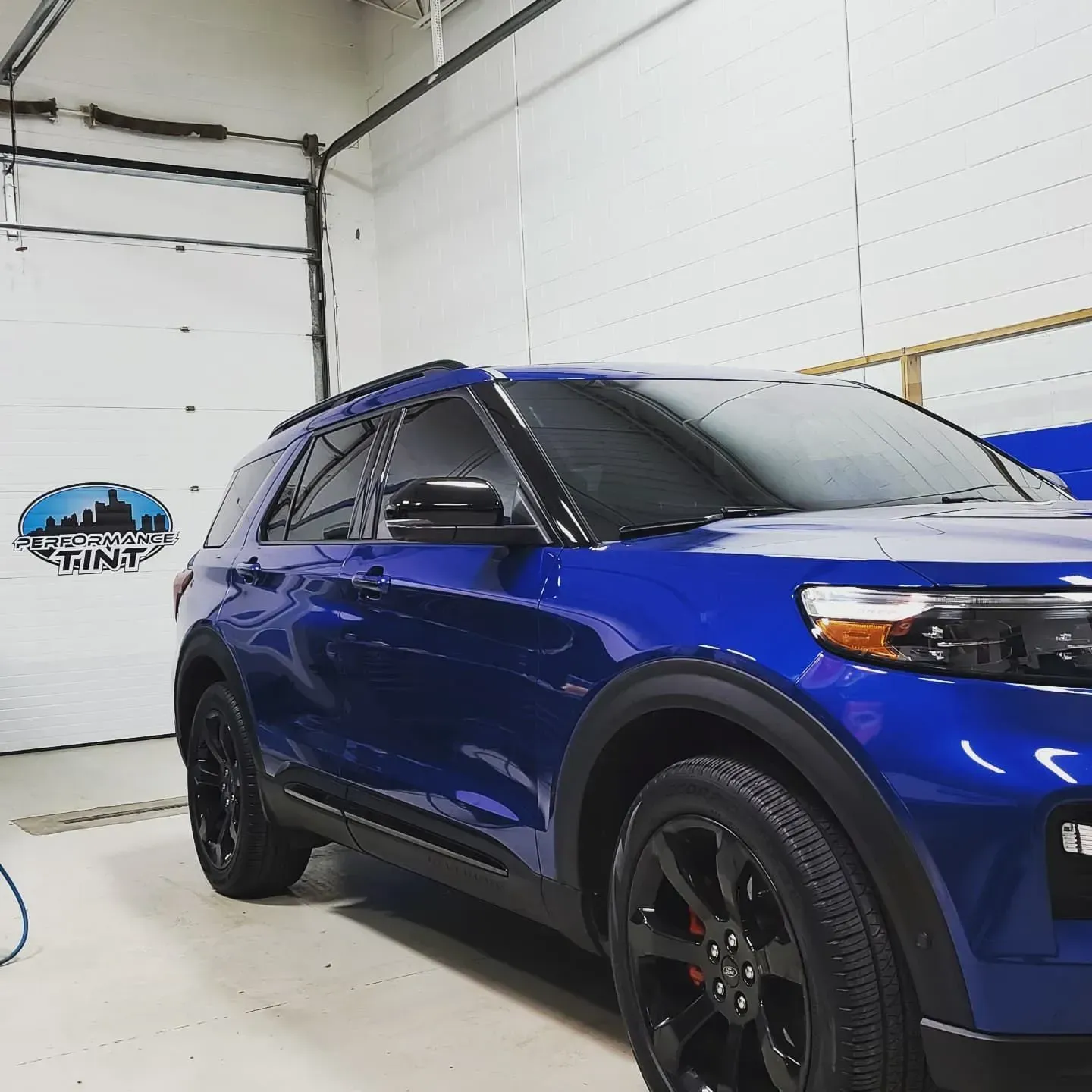 Blue SUV parked in a garage, angled front-left view with black wheels and tinted windows
