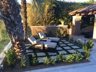 A patio with chairs and a palm tree in the background