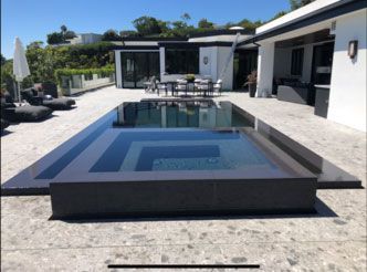 A large swimming pool in front of a house