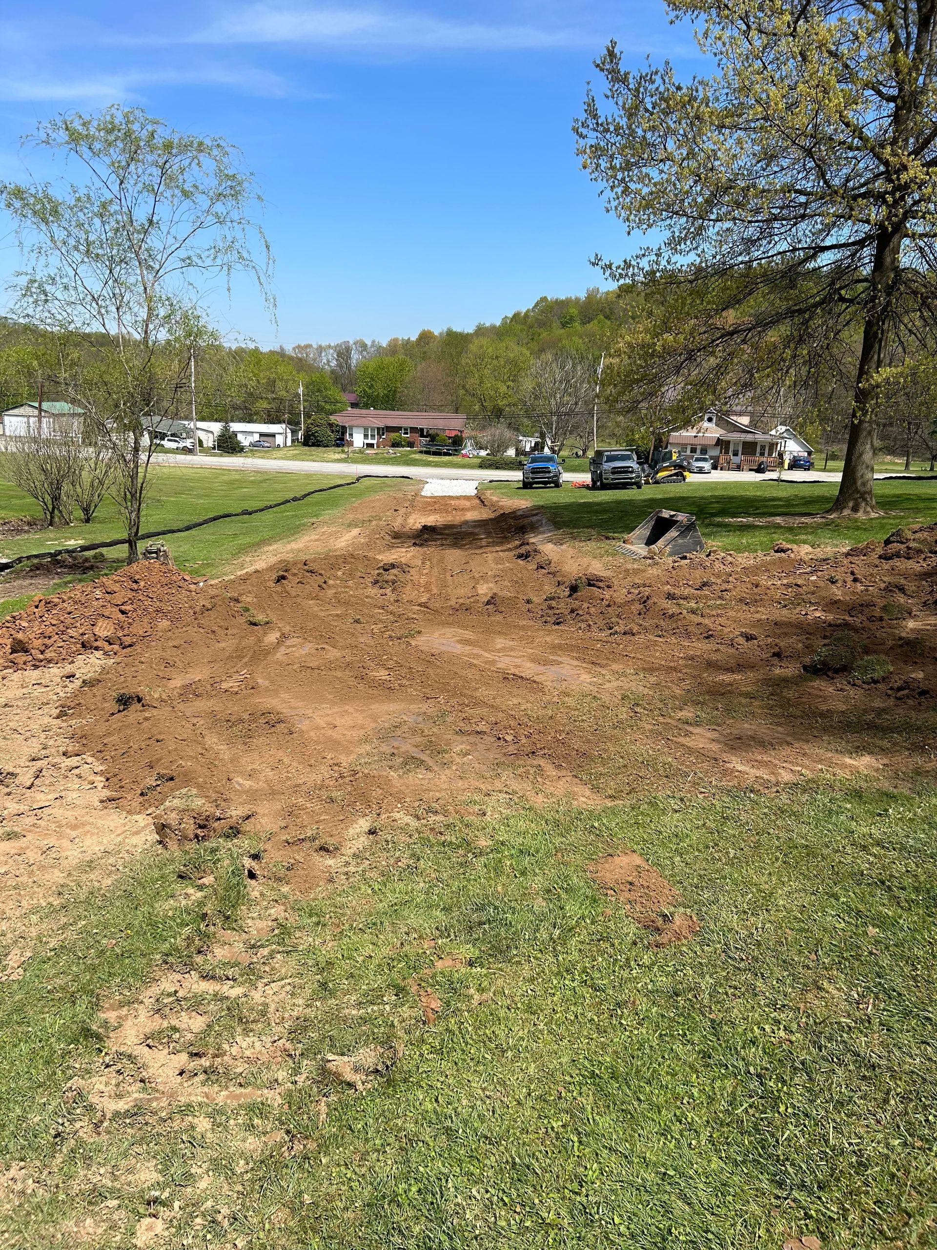 A large pile of dirt is in the middle of a grassy field.