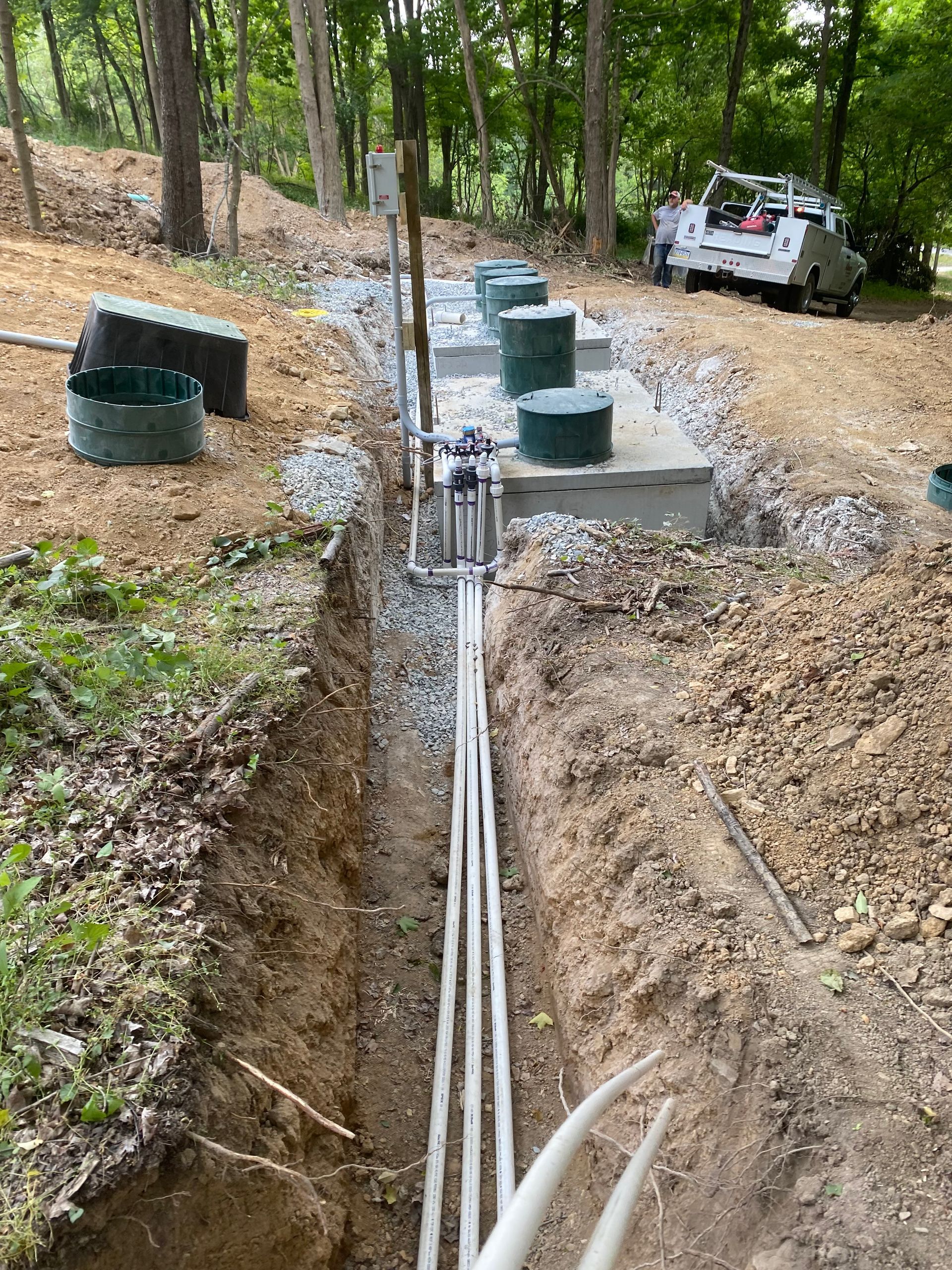 A septic system is being installed in the woods.