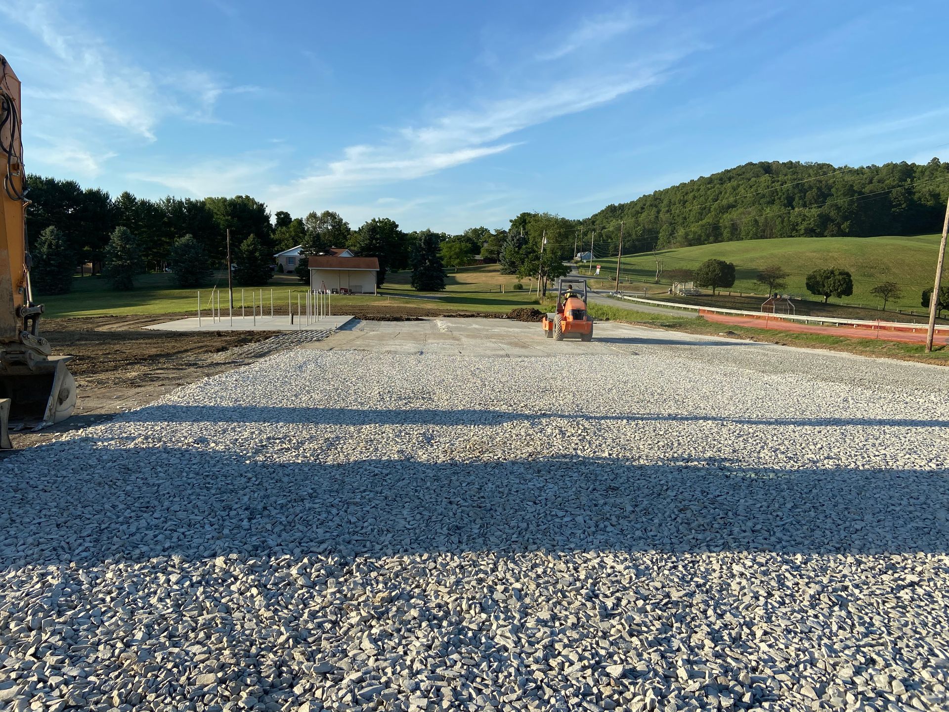 A construction site with a lot of gravel and a bulldozer in the background.