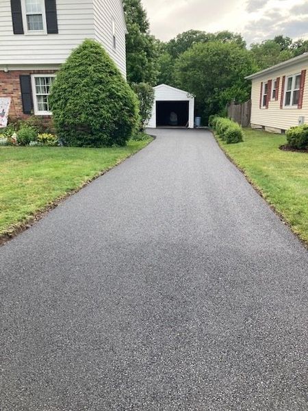 A driveway leading to a house with a garage.