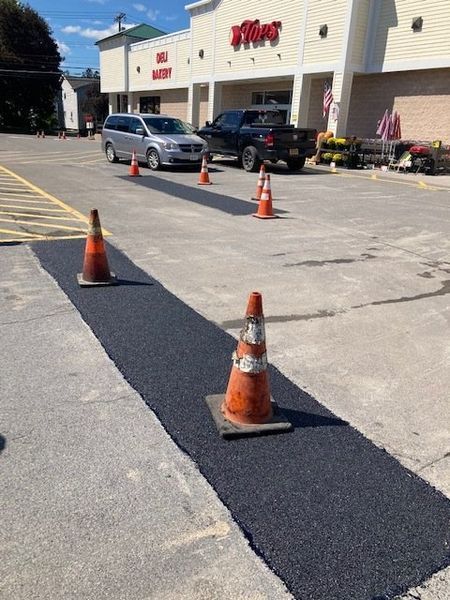 A parking lot with cones and cars parked in front of a store.