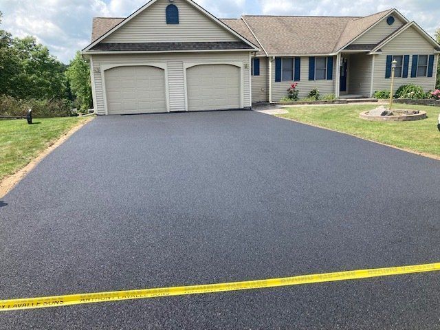 A house with a large driveway in front of it.