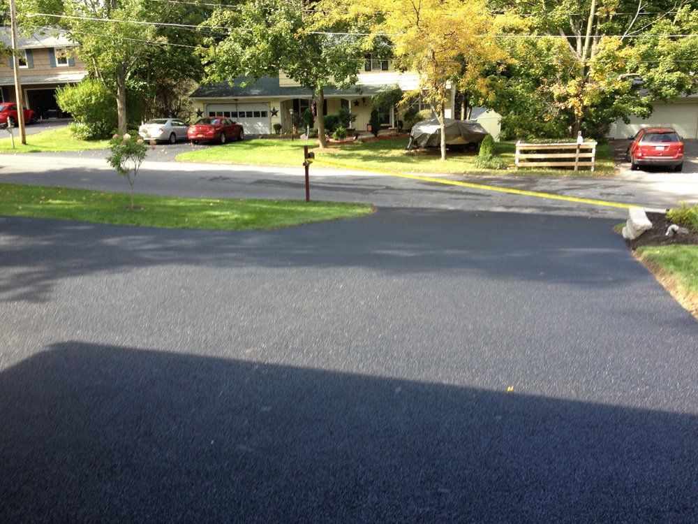 A driveway with cars parked in front of a house