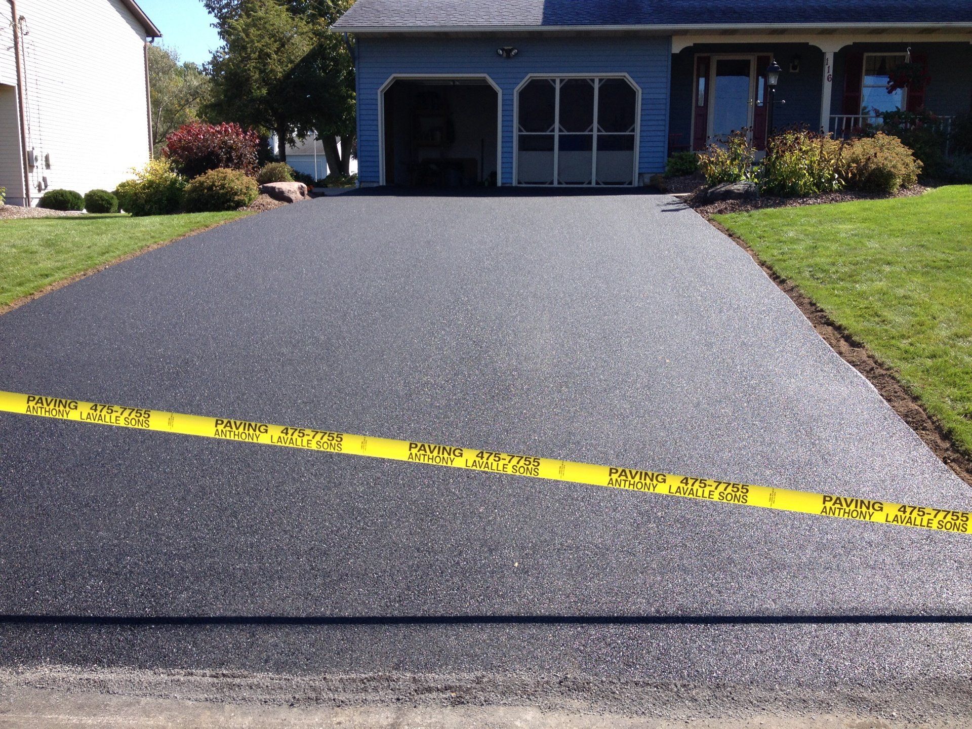 A driveway with a yellow tape that says do not enter