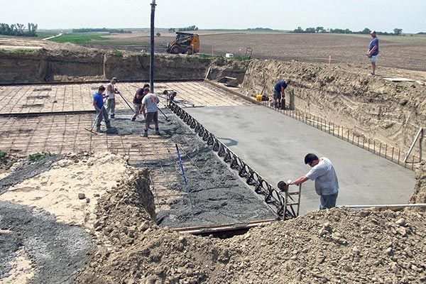 A group of construction workers are working on a concrete floor