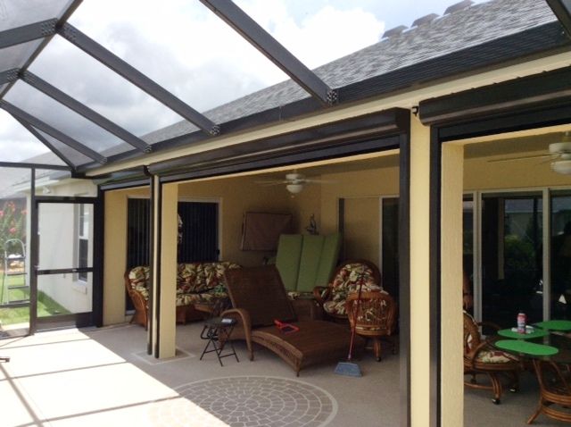 Covered patio with outdoor seating and open glass doors leading inside the house