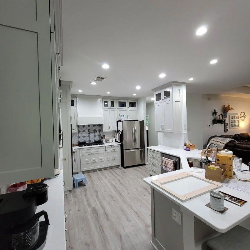 A kitchen with white cabinets and a stainless steel refrigerator