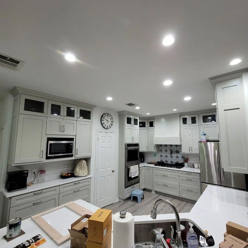 A kitchen with white cabinets and a clock on the wall