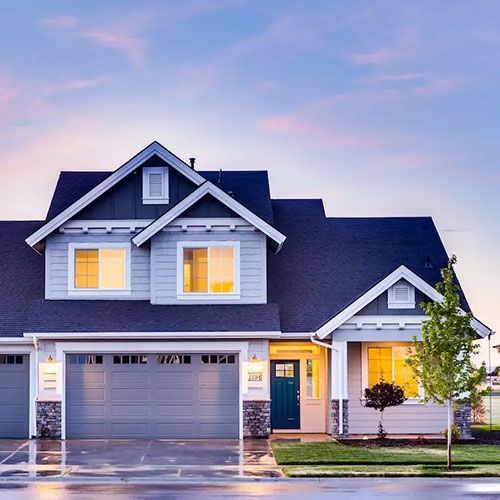 A large house with a gray garage door and a blue door.