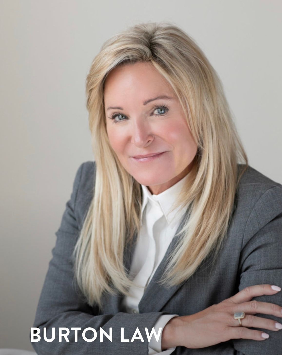 Portrait of a woman in a gray blazer and white shirt with “BURTON LAW” text
