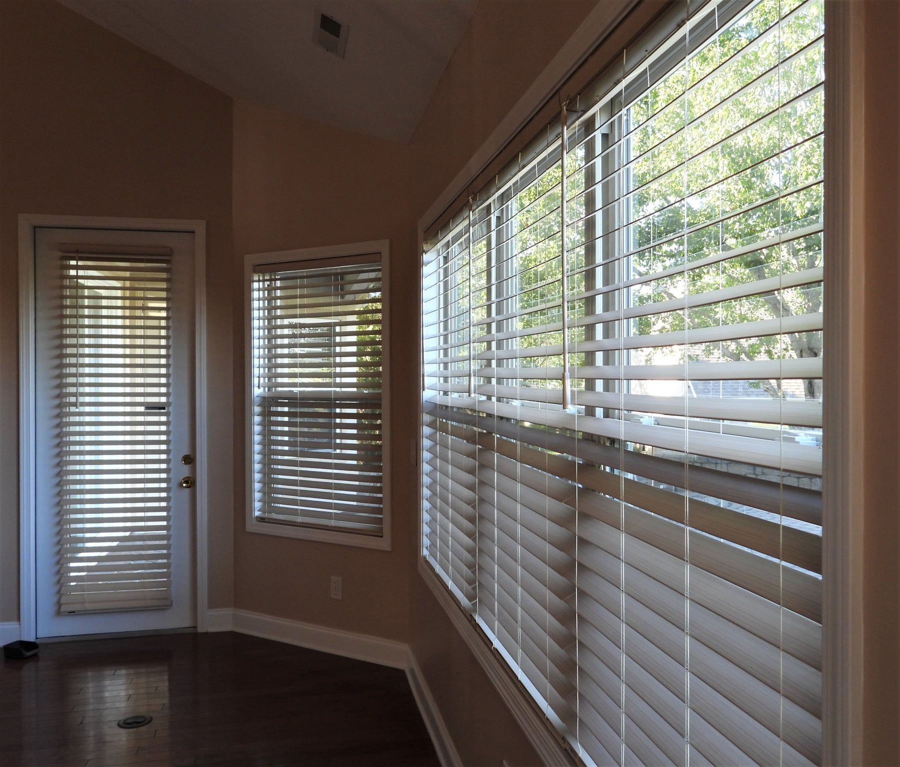 Interior room with three windows and door, all with closed blinds.
