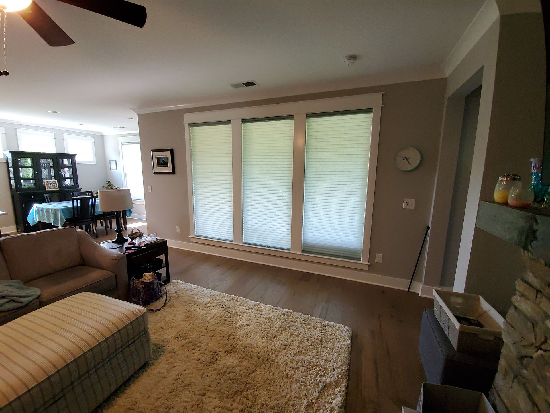 Living room with large windows, tan walls, and a fluffy rug.