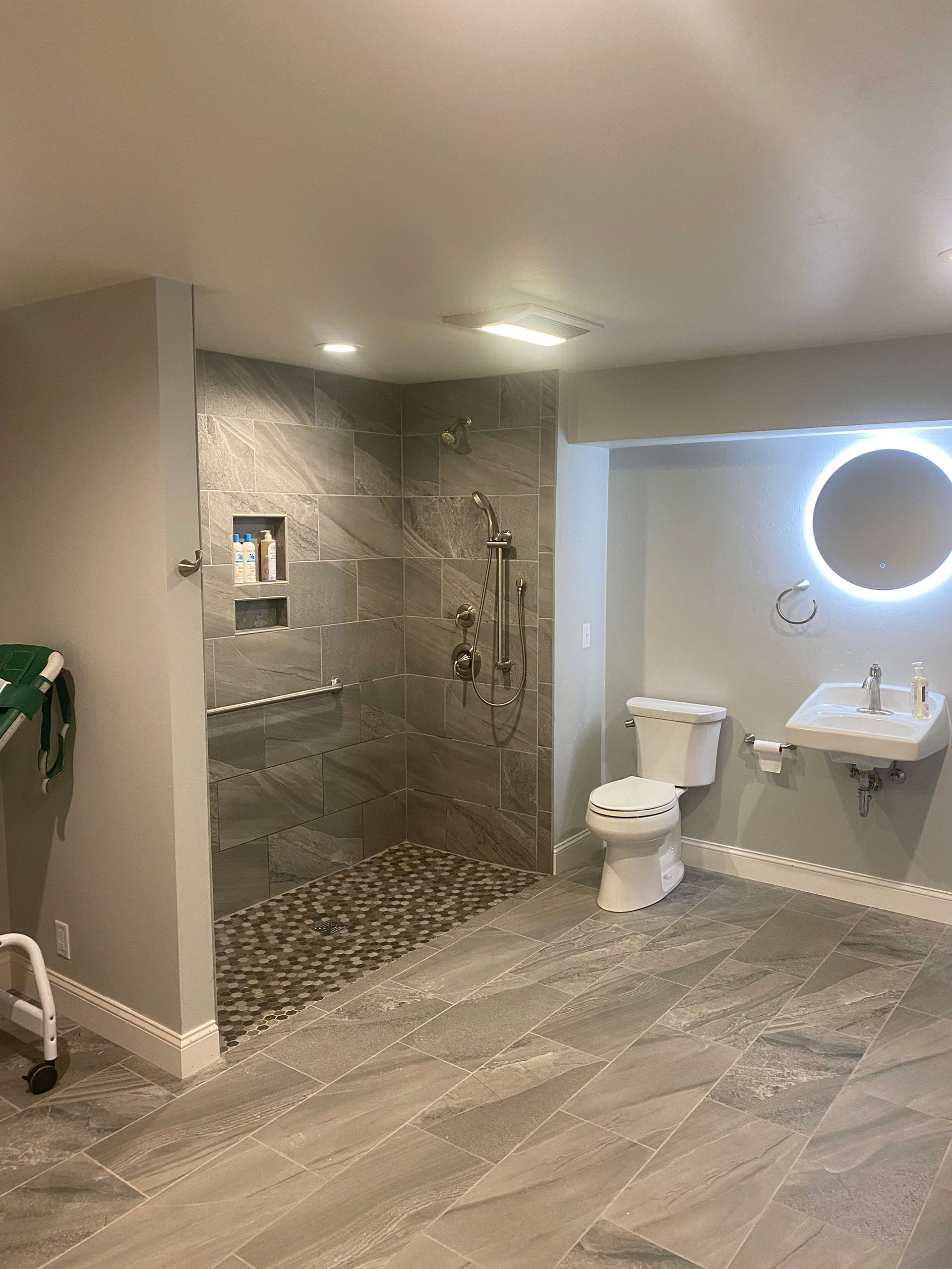 A bathroom with a walk in shower, toilet, sink and mirror.