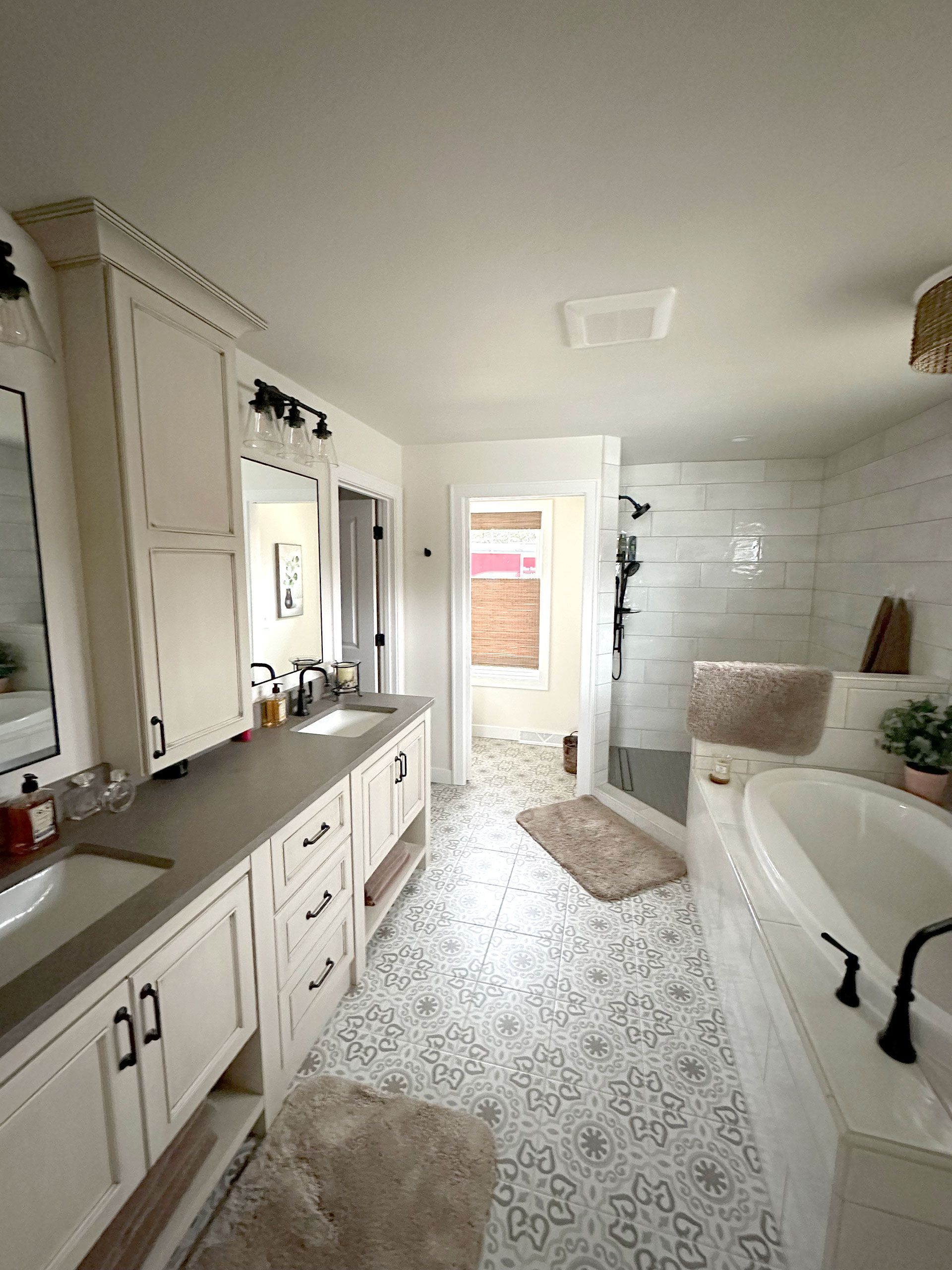 A bathroom with a tub, sink and mirror.