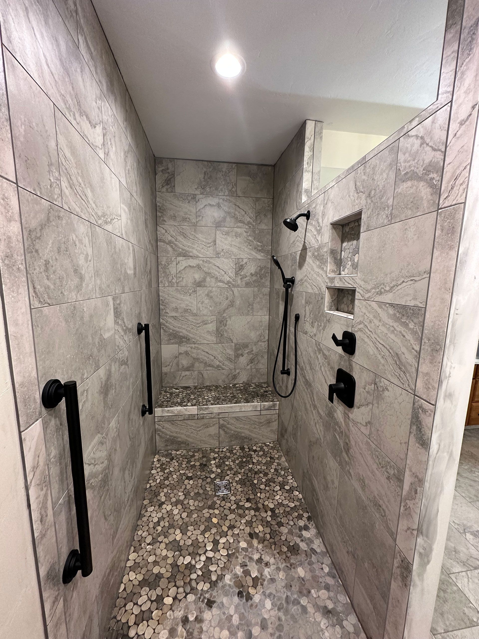 A bathroom with a walk in shower and a tiled floor.