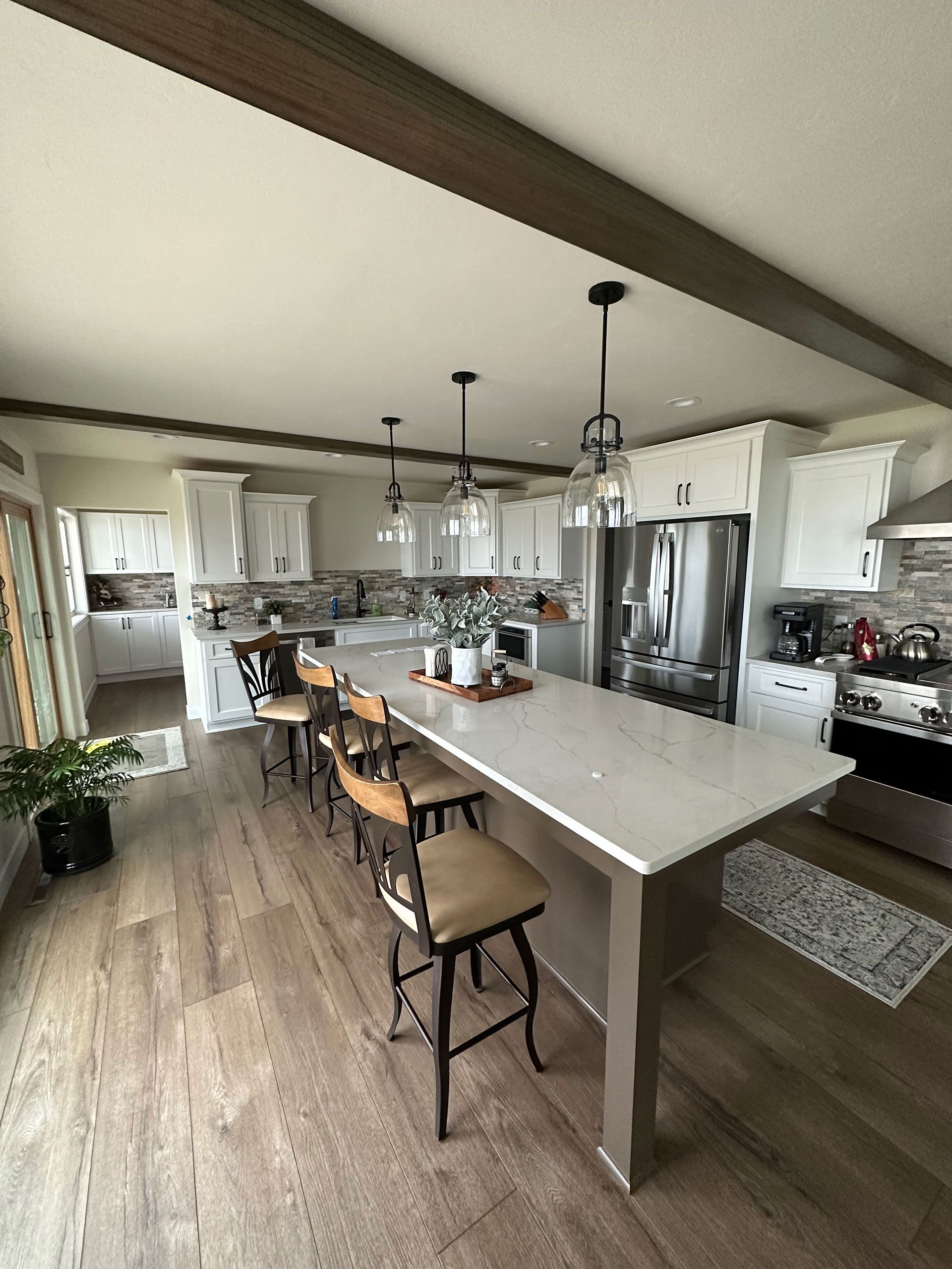A kitchen with a large island and stools.