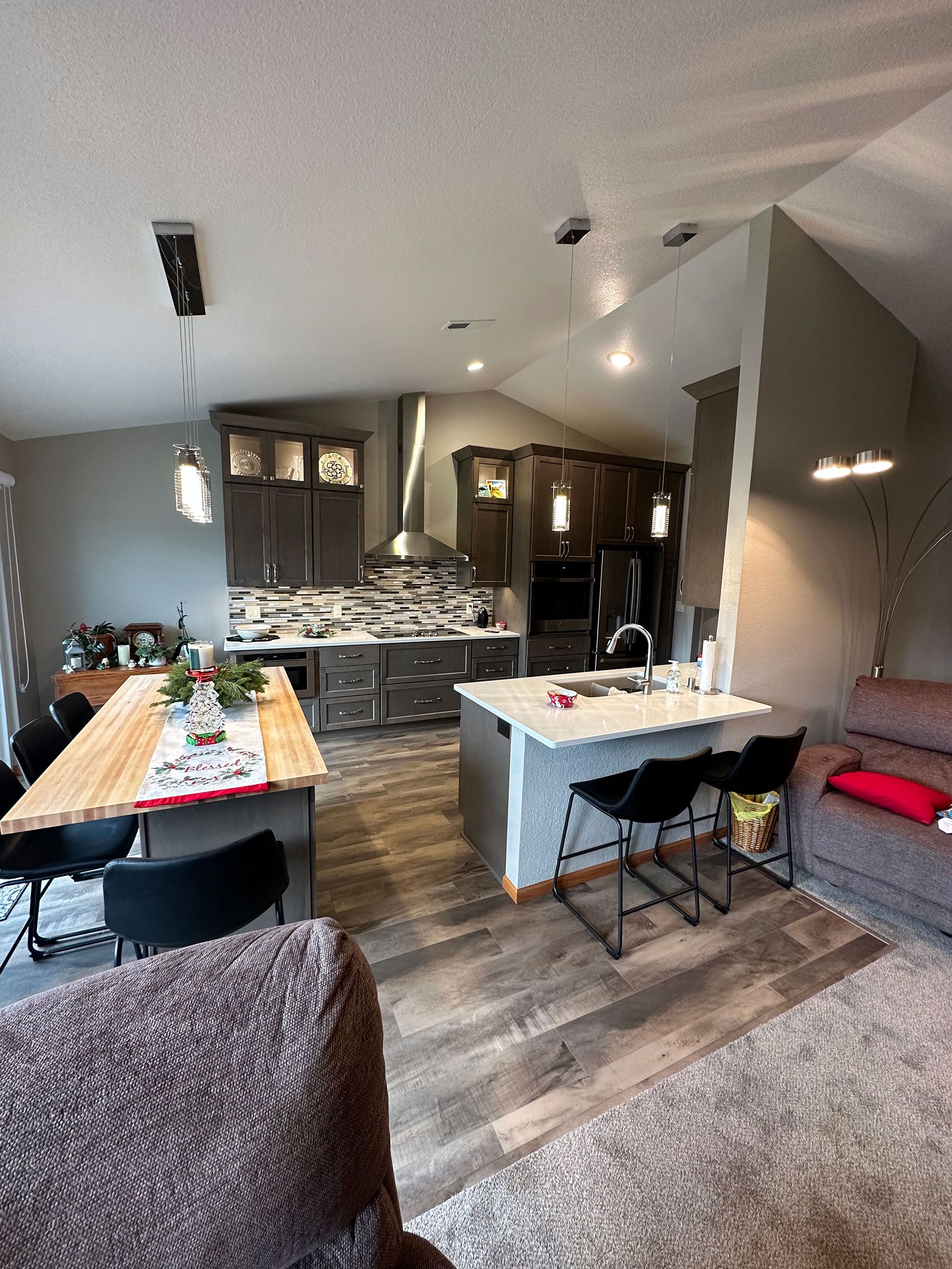 A living room with a couch, table, chairs and a kitchen.