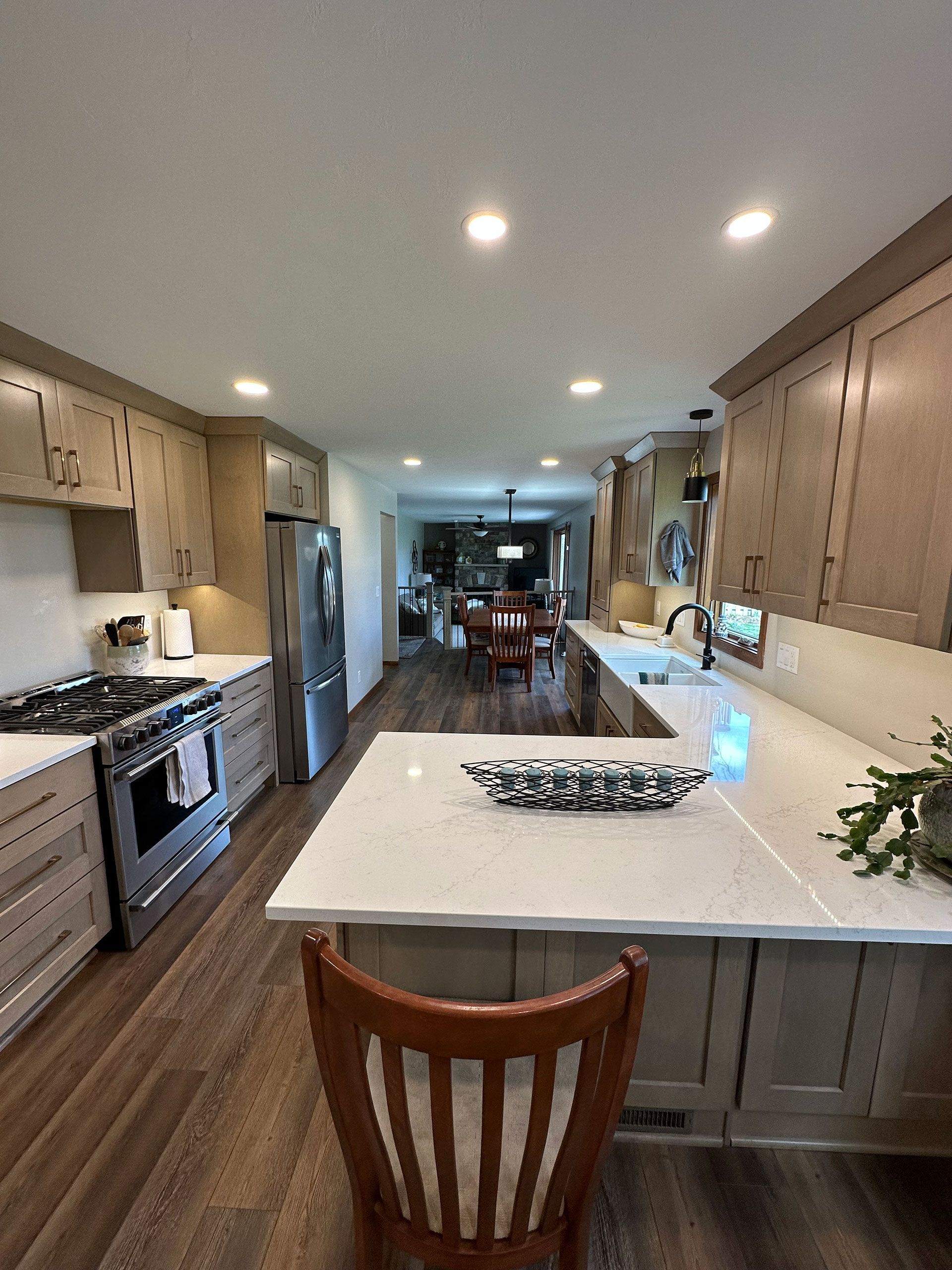 A kitchen with a large island and a chair in the middle.