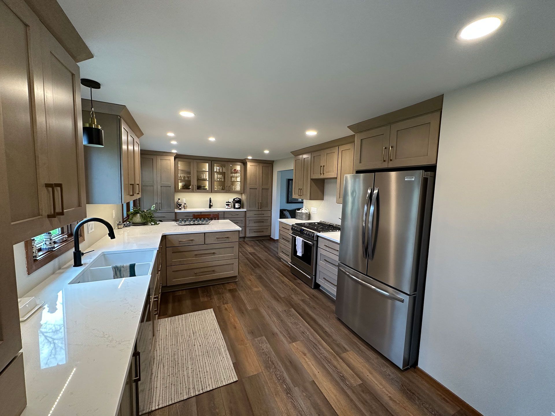 A kitchen with stainless steel appliances and wooden floors.