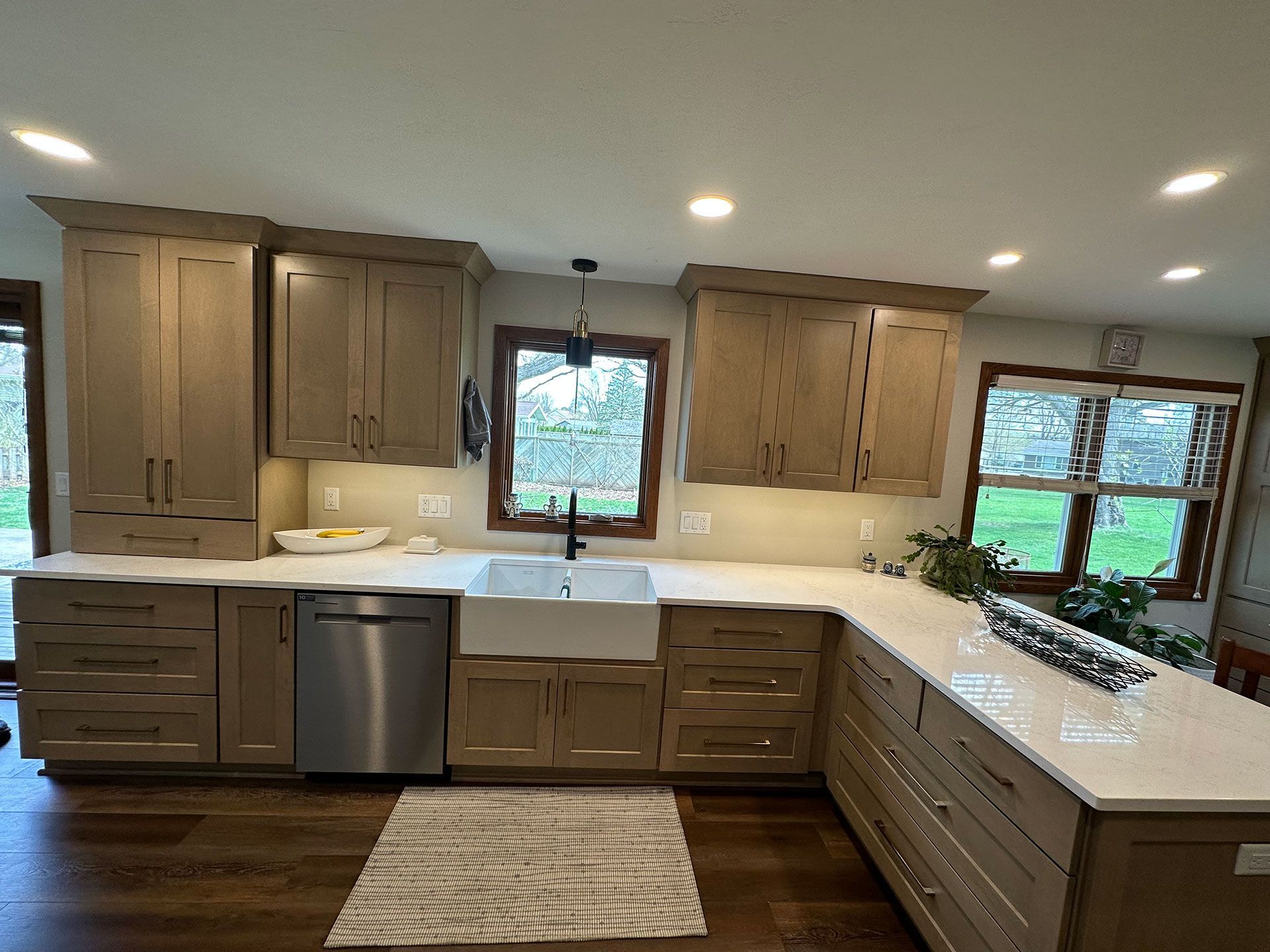 A kitchen with wood flooring and wooden cabinets.