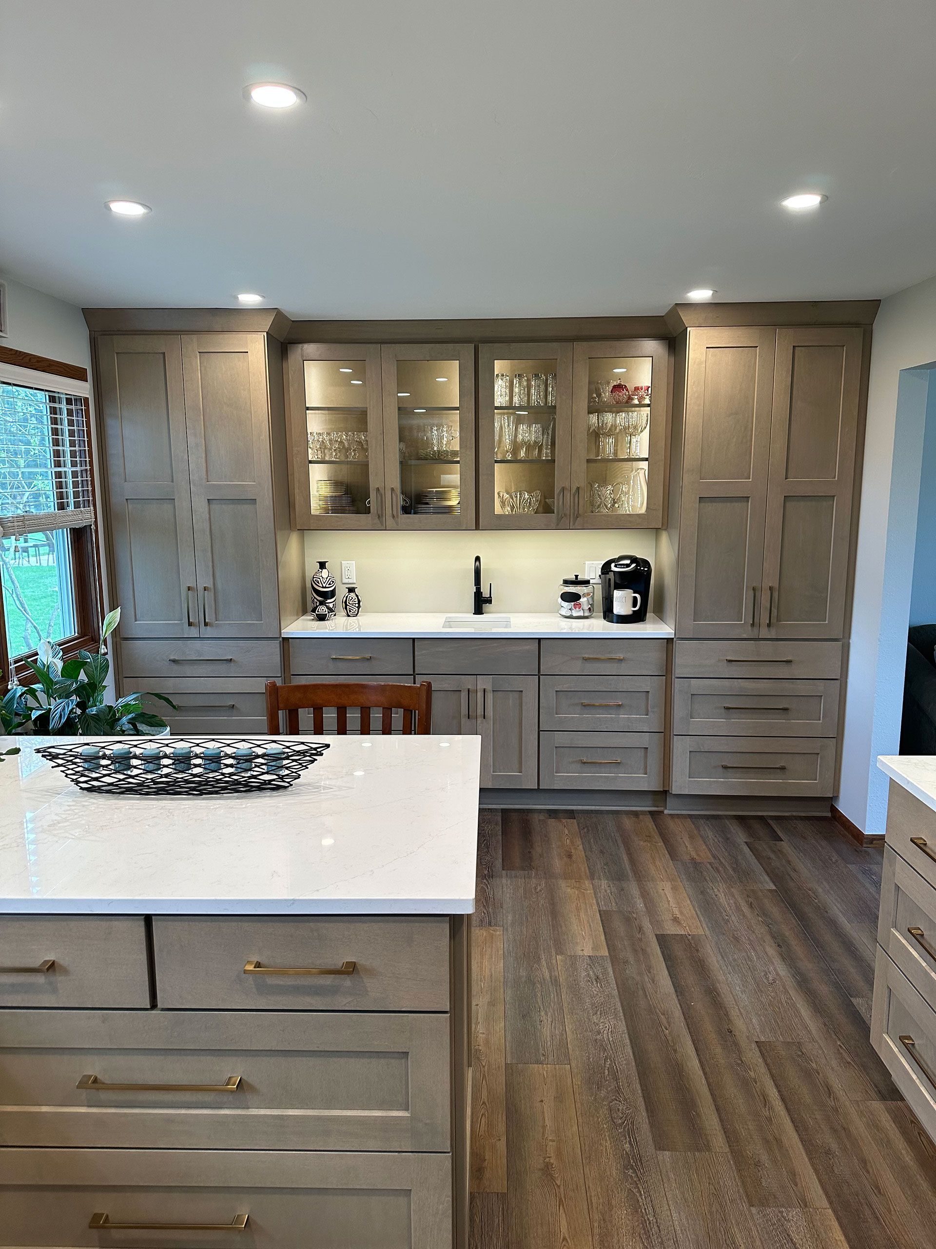 A kitchen with a large island and lots of cabinets and drawers.
