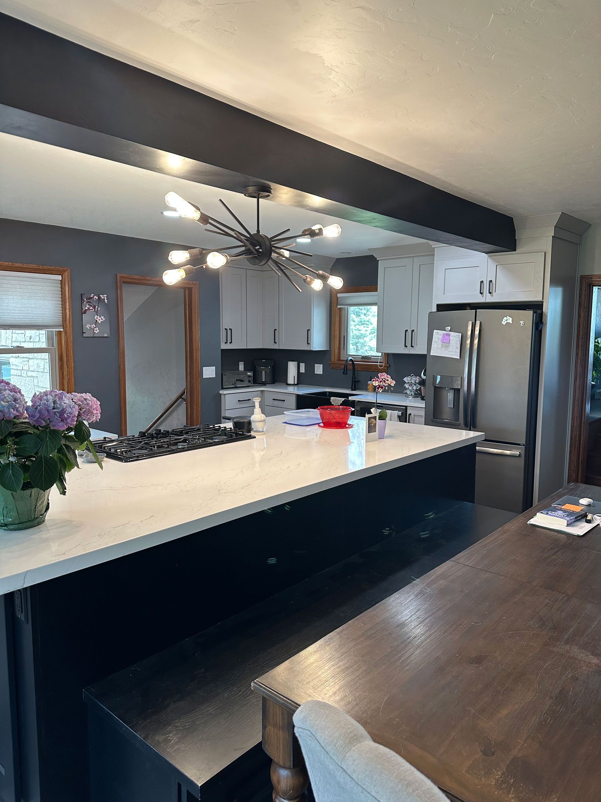 Kitchen with a large white countertop island and a dining table.
