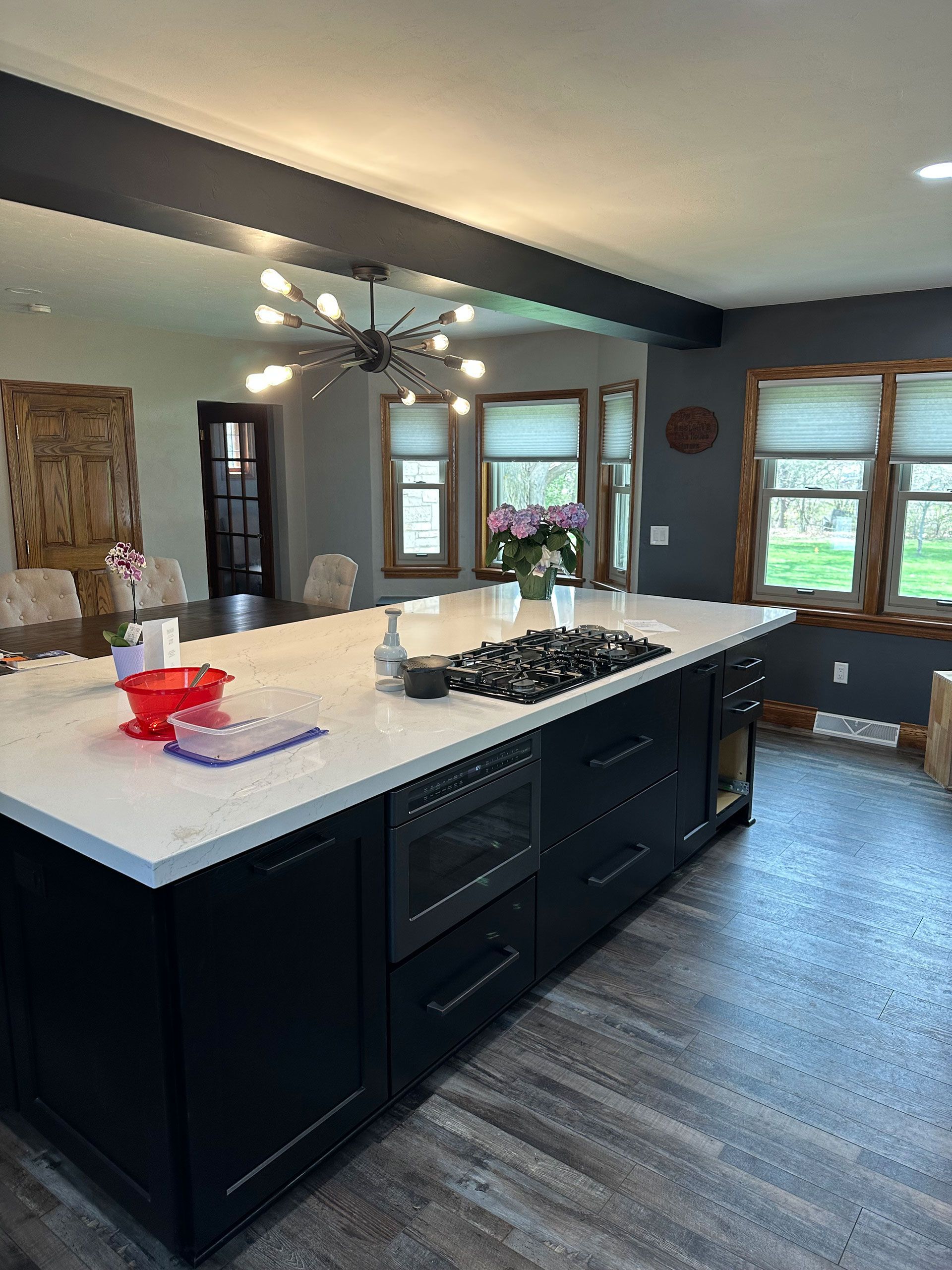 A kitchen with a large island and a stove top oven.