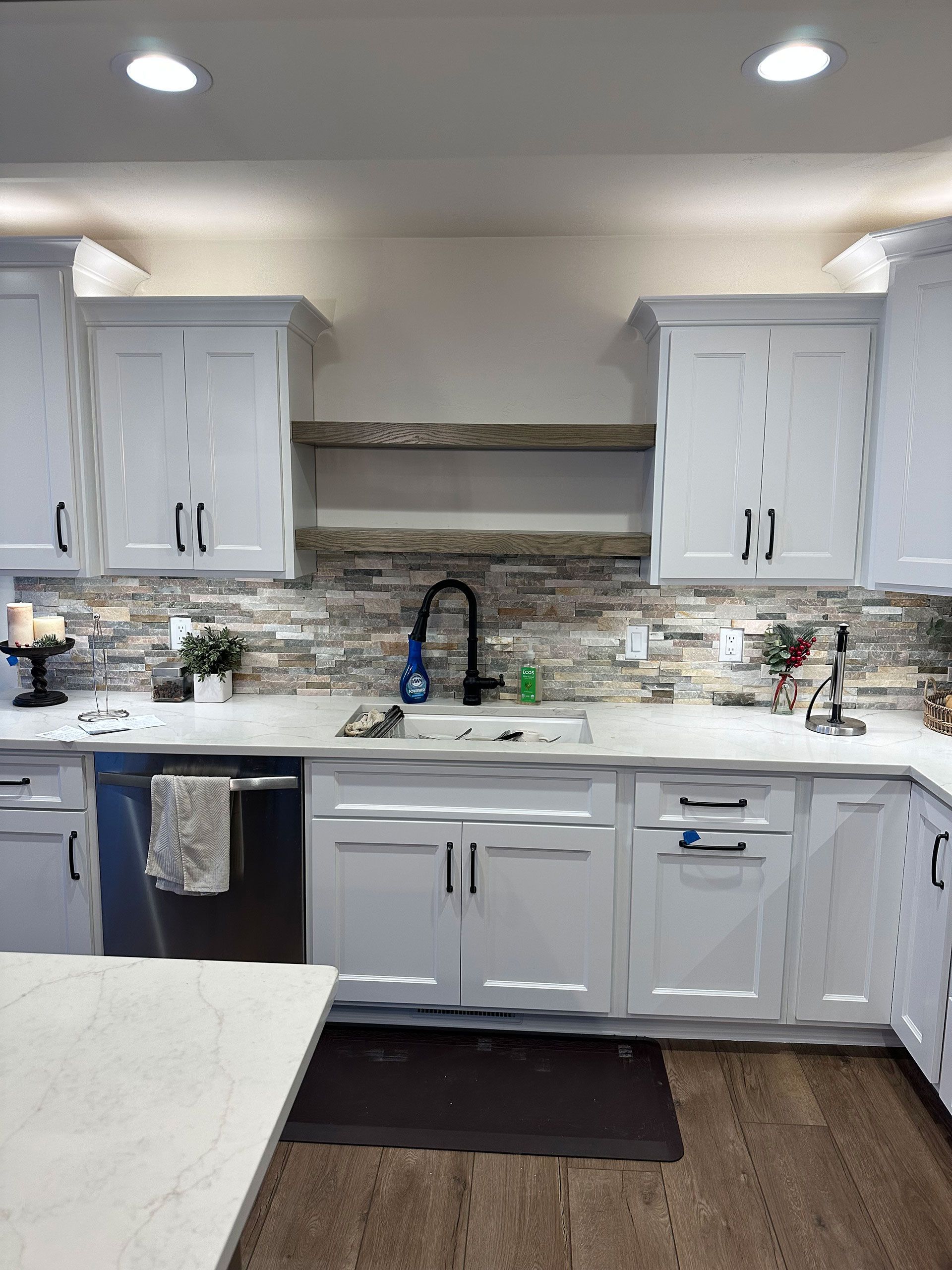 A kitchen with white cabinets, a sink, and a dishwasher.