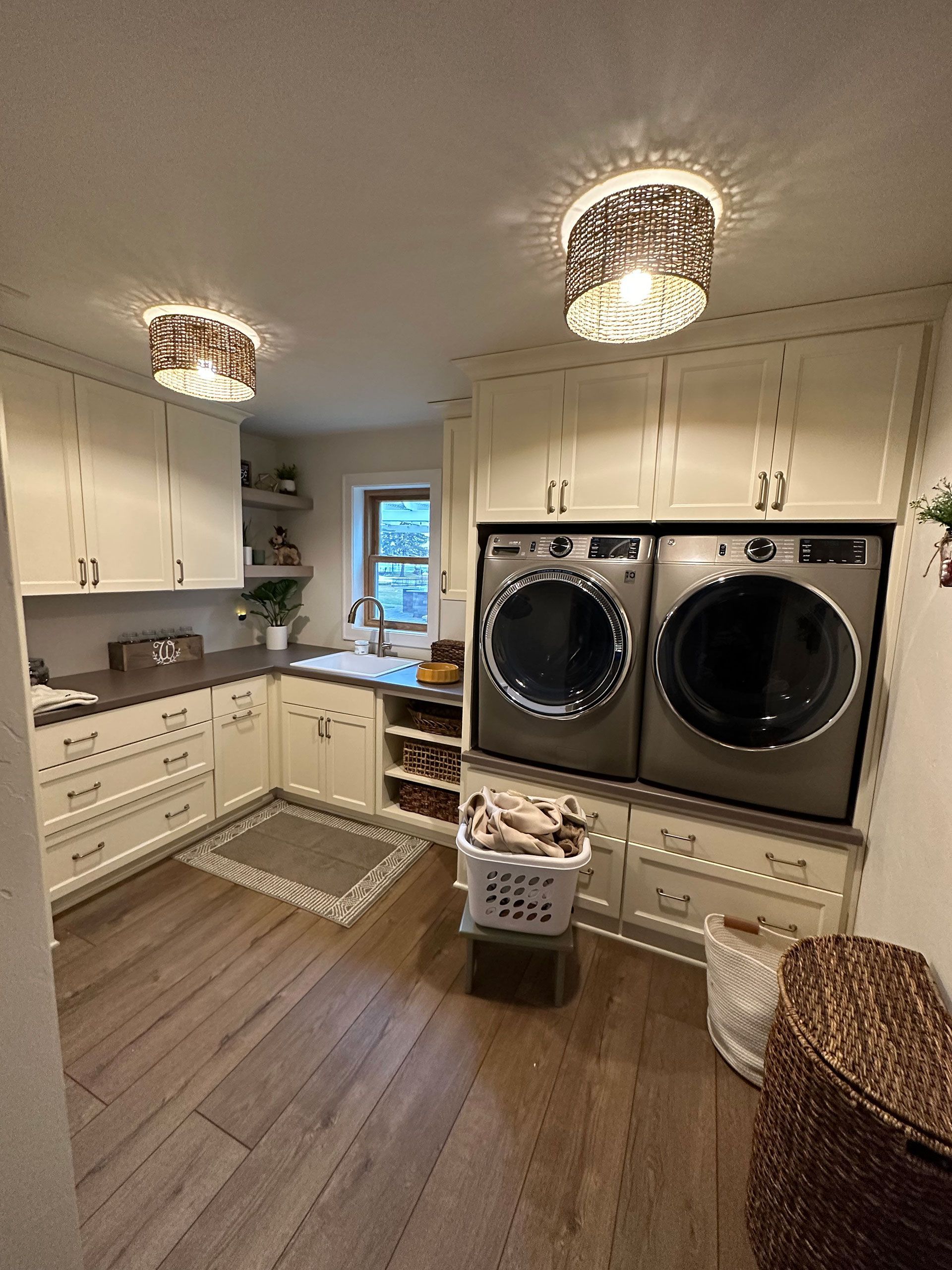 A laundry room with a washer and dryer and a basket of clothes.