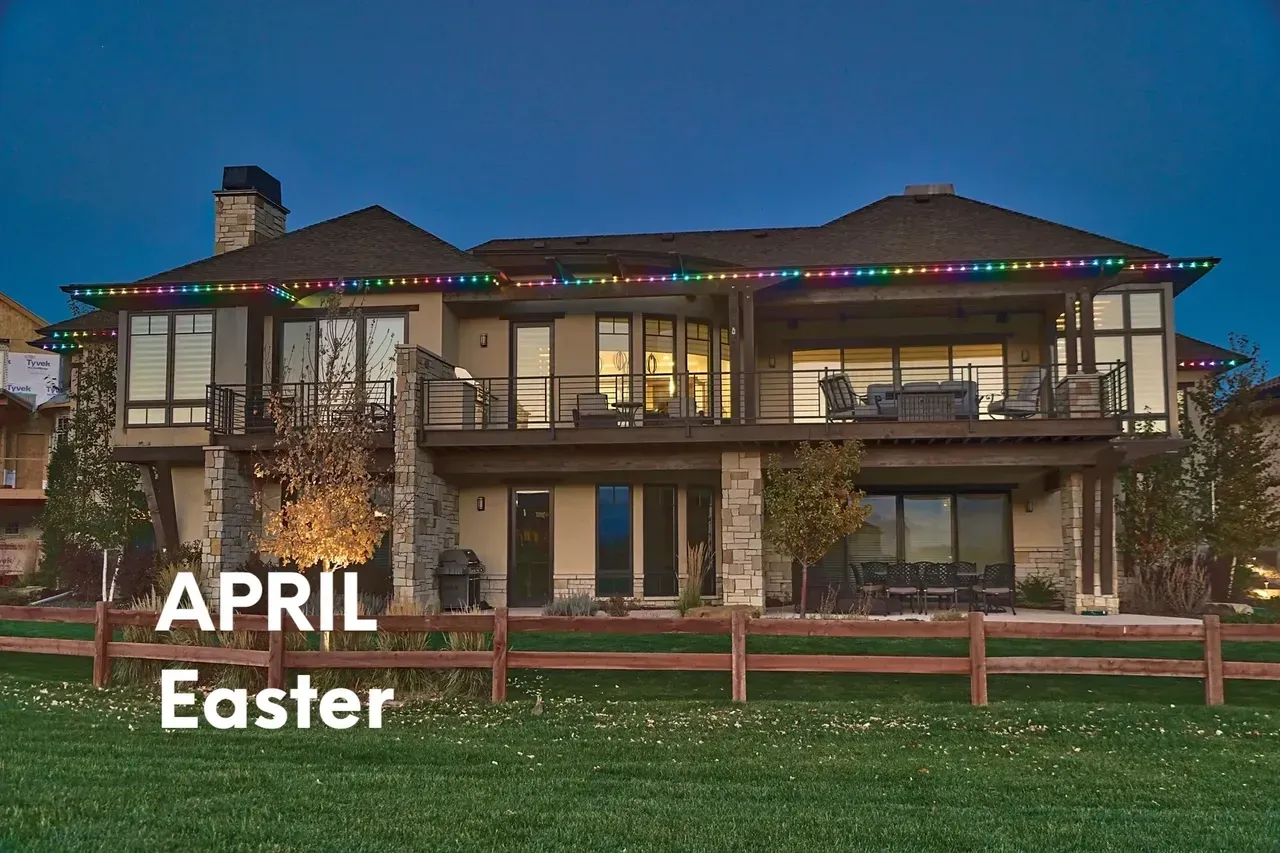 A large house with colorful lights along the roofline against a twilight sky, April Easter text.
