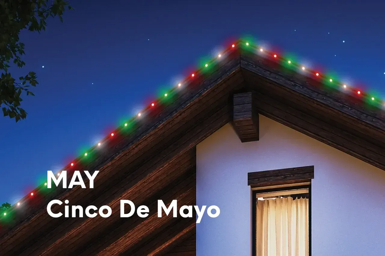 Green, red, and white lights on a house's roof. 