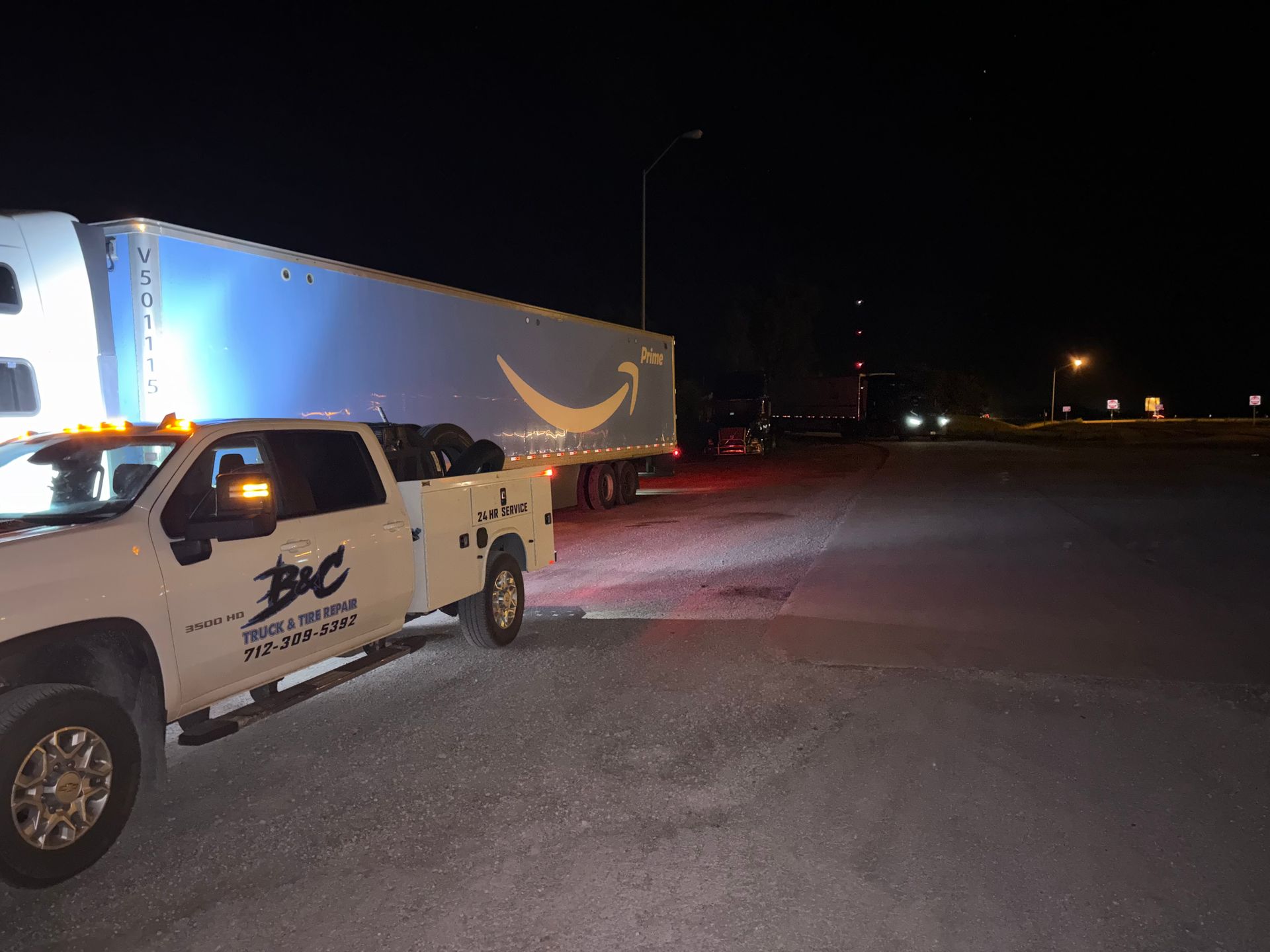 Pickup truck with a large trailer parked at night on a dark roadside