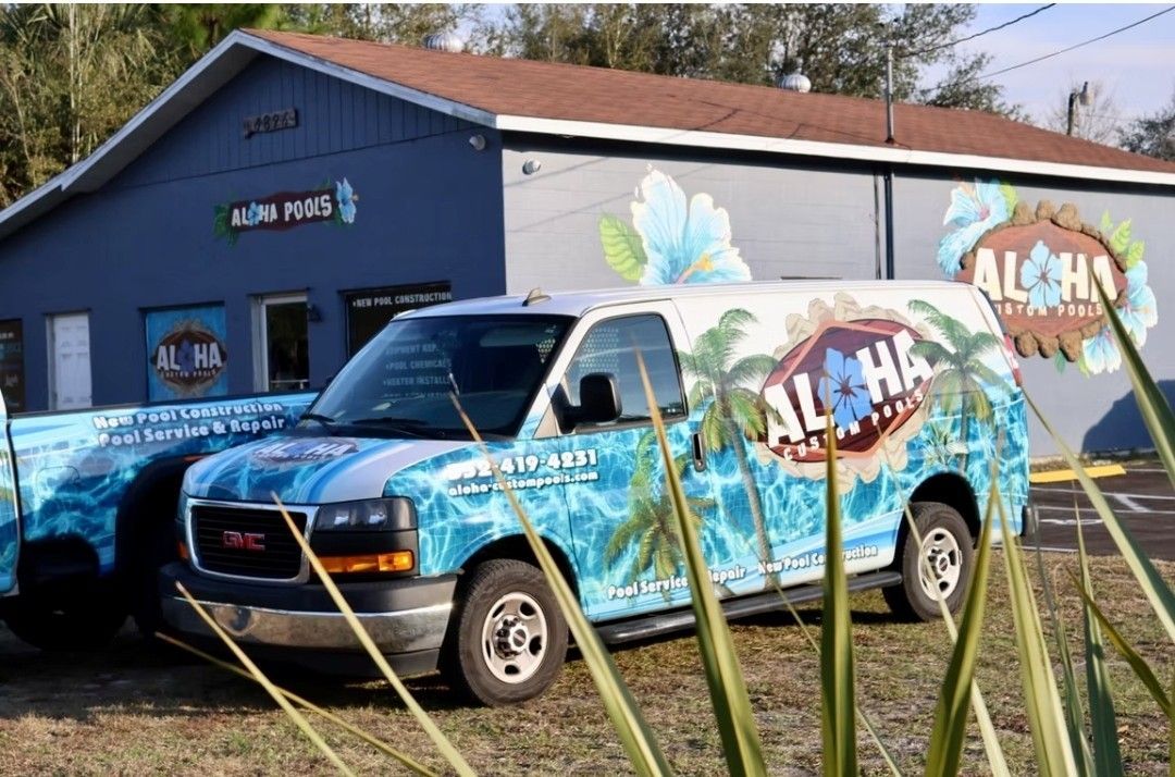 A man is cleaning a swimming pool with a vacuum cleaner.