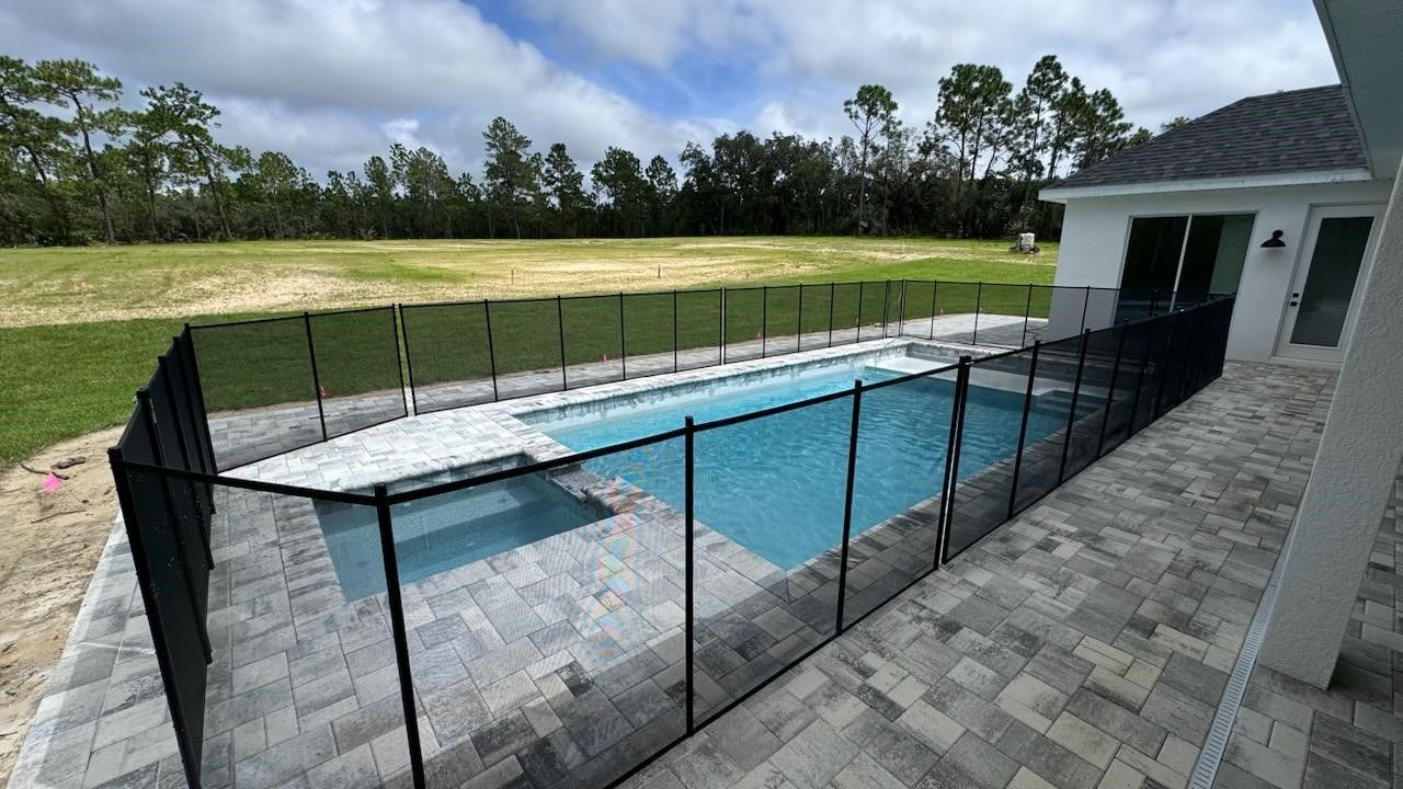 A large swimming pool surrounded by a black fence.