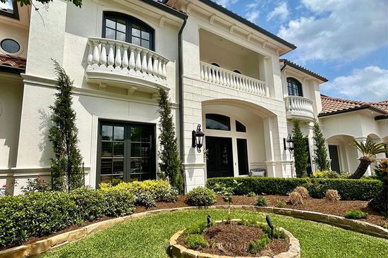 A large white house with a lush green lawn in front of it