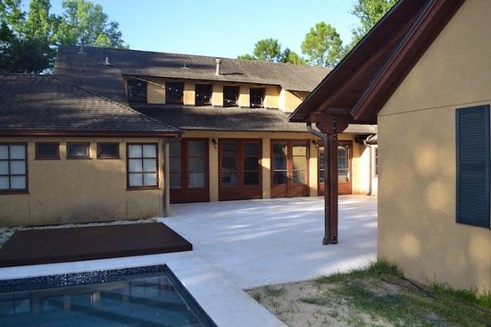 A large house with a swimming pool in front of it