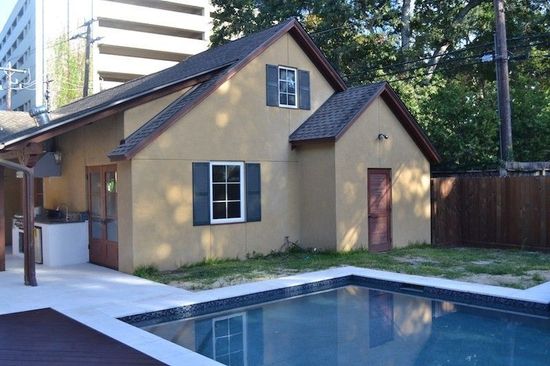 A house with a swimming pool in front of it