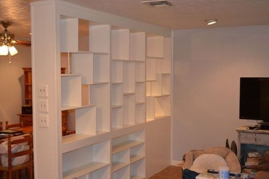 A living room with lots of shelves and a television