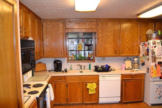 A kitchen with wooden cabinets and a white refrigerator