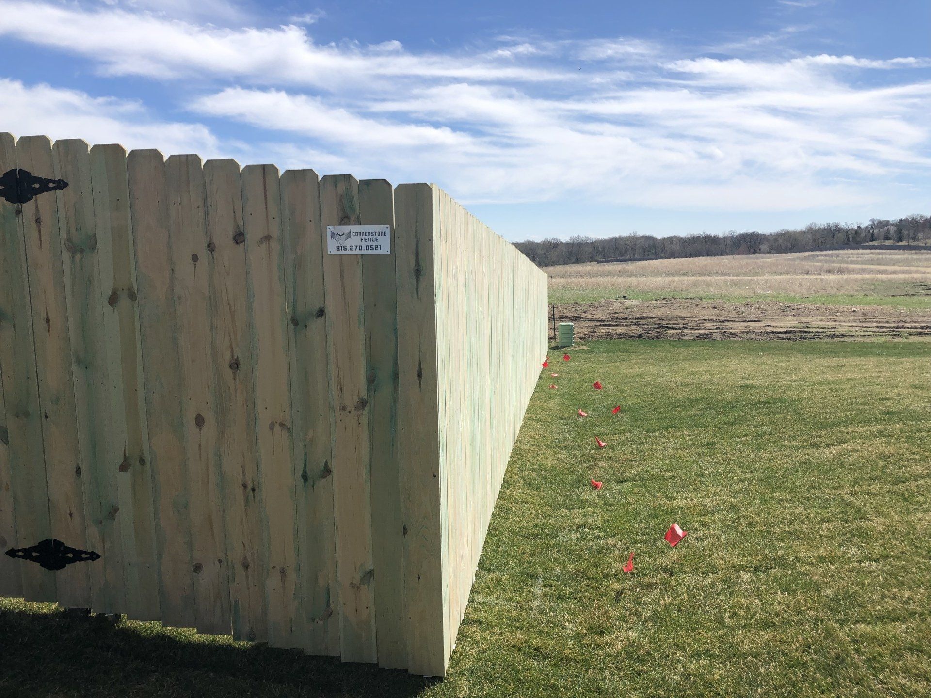 A wooden fence is sitting in the middle of a grassy field.