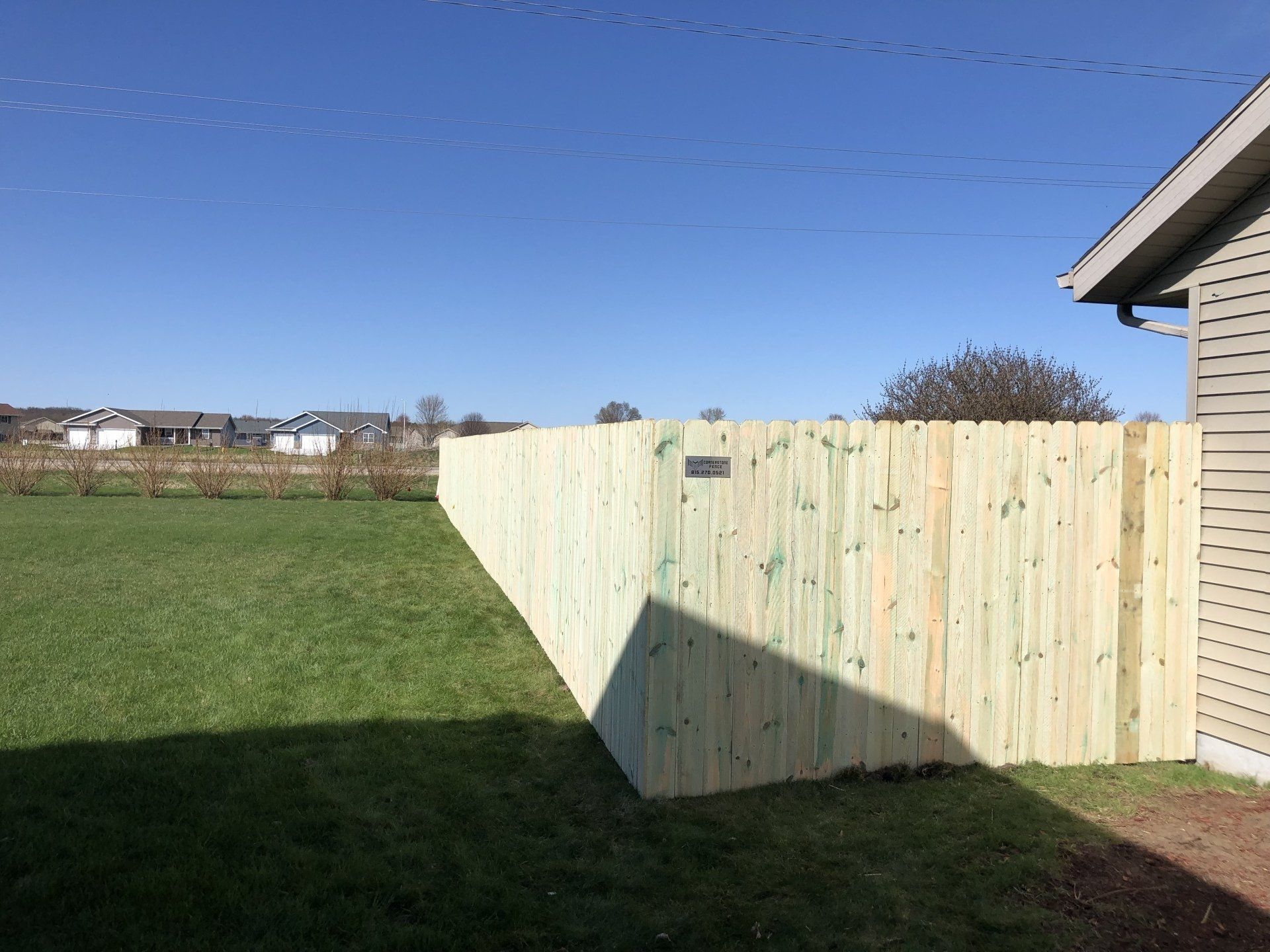 A wooden fence is in the backyard of a house