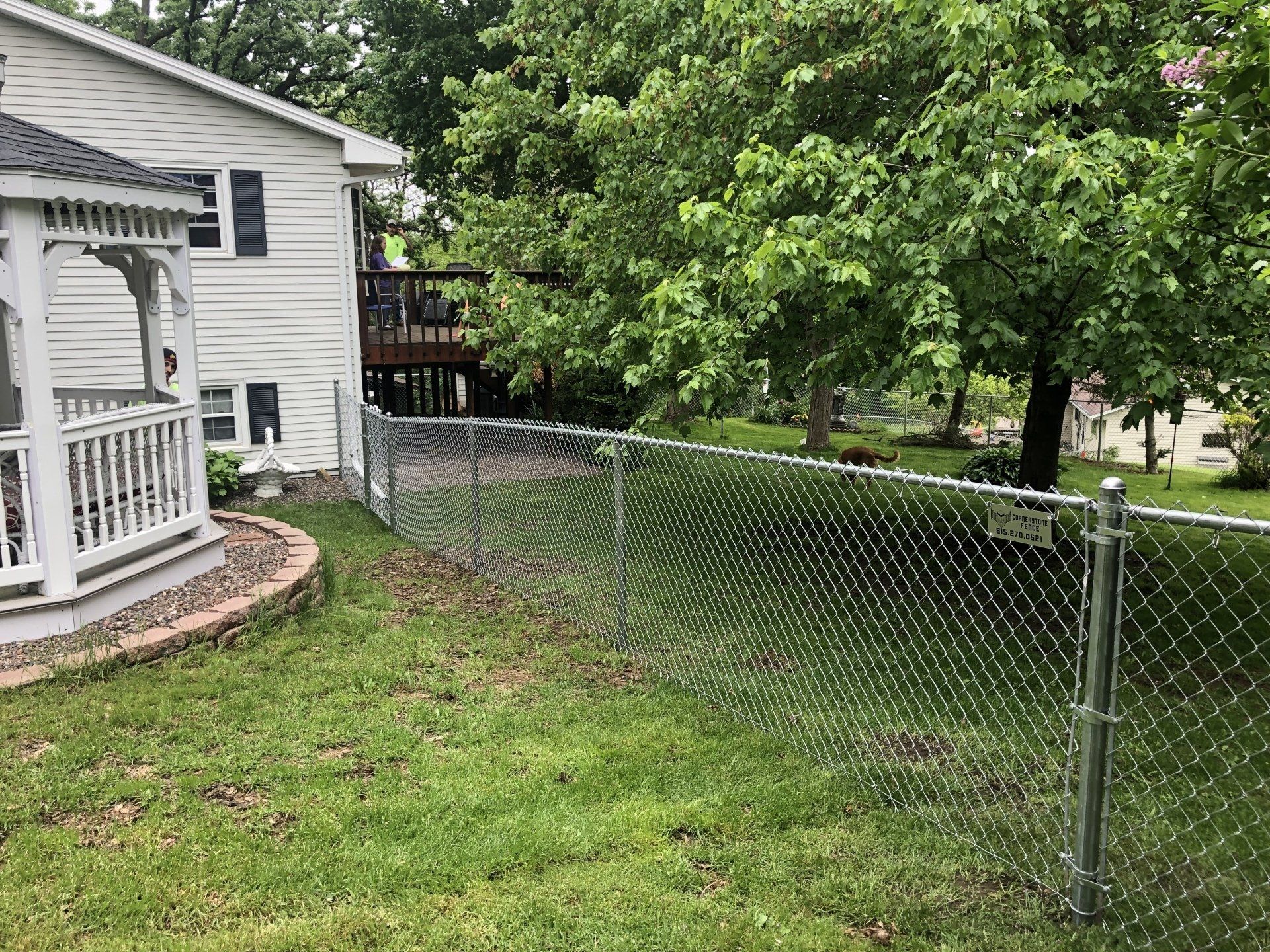 There is a chain link fence in the backyard of a house.