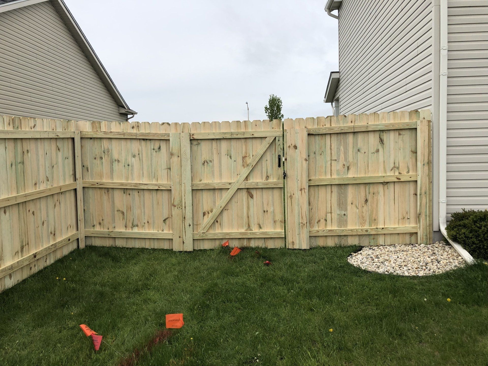 A wooden fence with a gate in the backyard of a house.