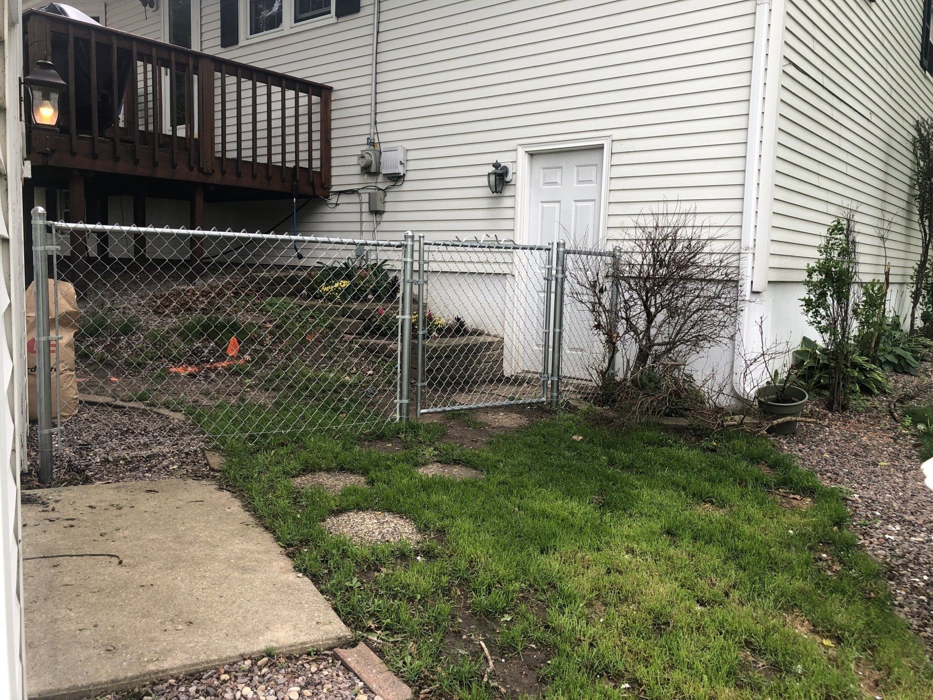 There is a chain link fence in the backyard of a house.